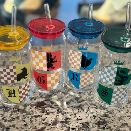 Four Hogwarts house glasses in yellow, red, blue, and green, one for each member of the family